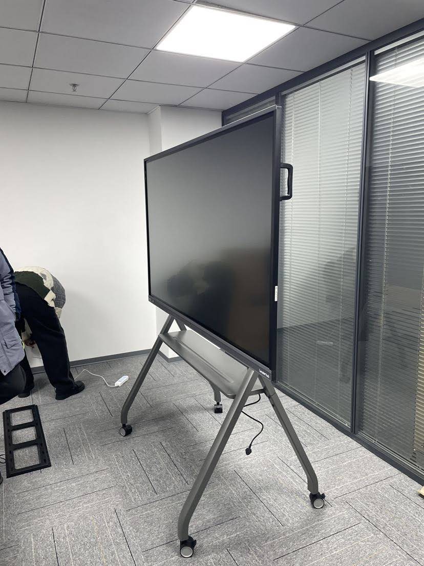 Multiple users collaborating on interactive smart board in meeting room
