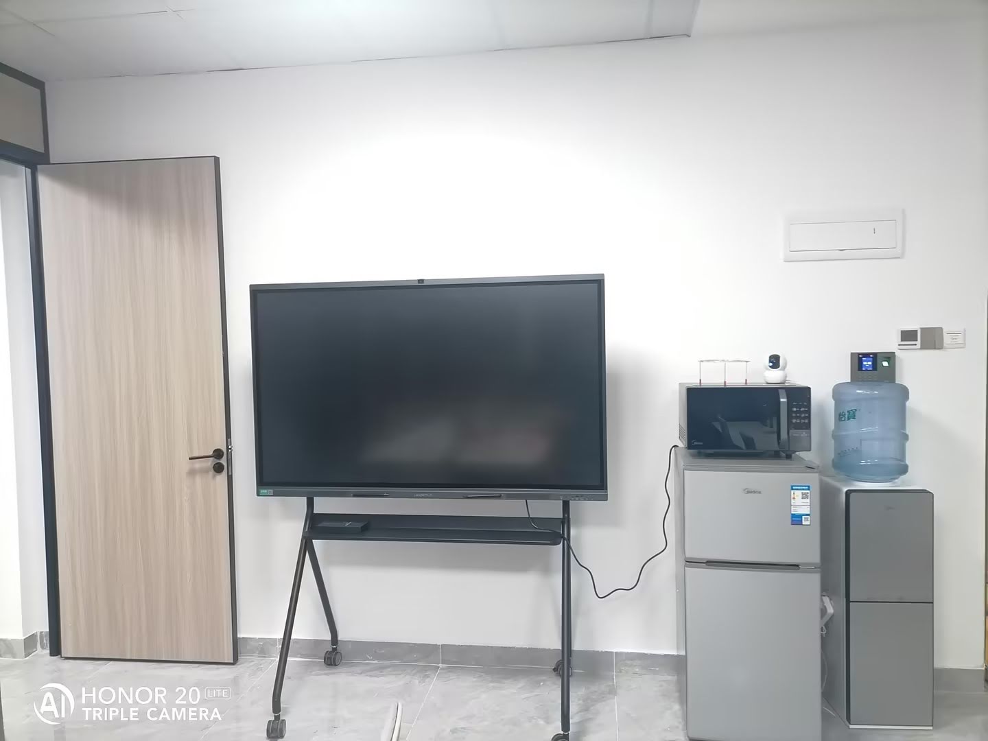 Instructor using laptop connected to interactive smart board during presentation