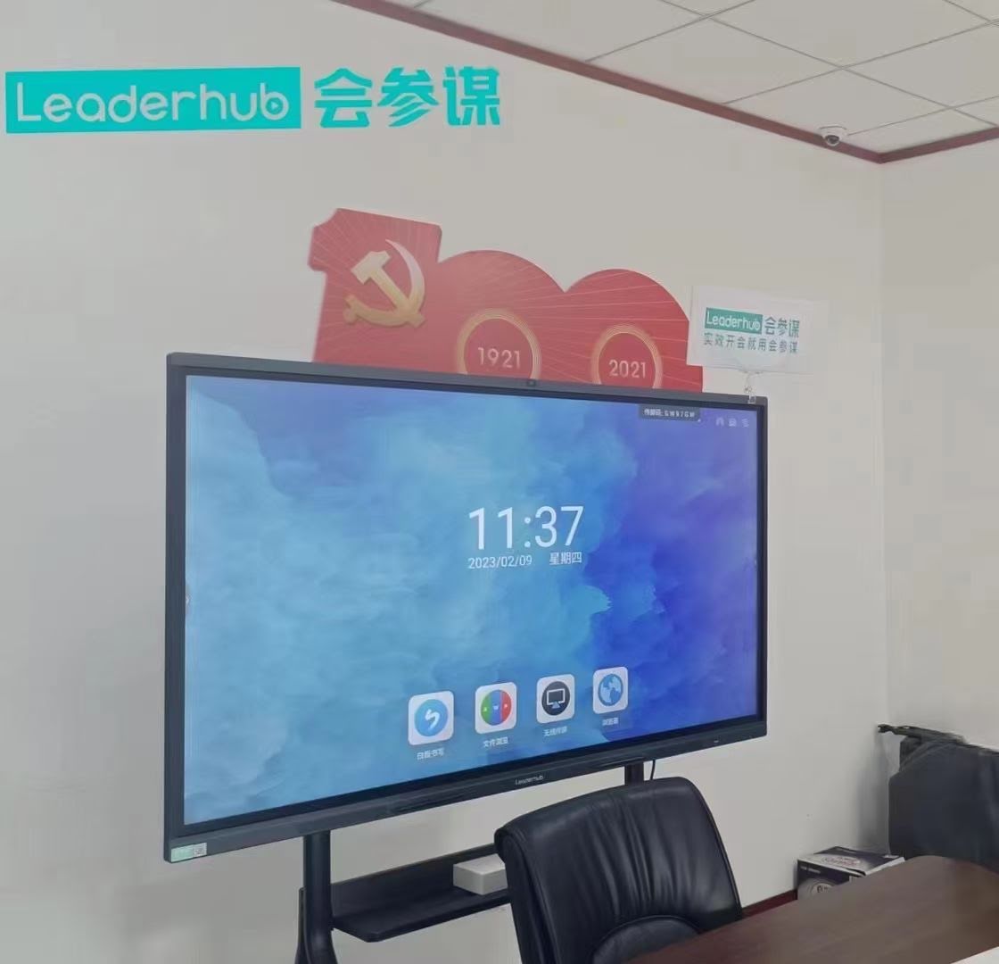 Business team collaborating using wireless laptop connection to large interactive display panel